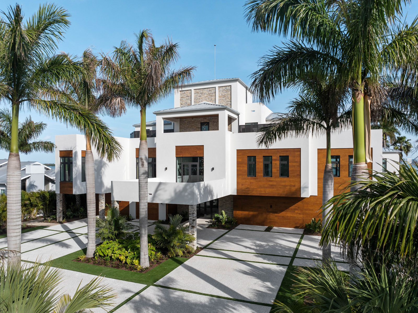 Contemporary waterfront home on Siesta Key with palm-lined drive and modern coastal architecture