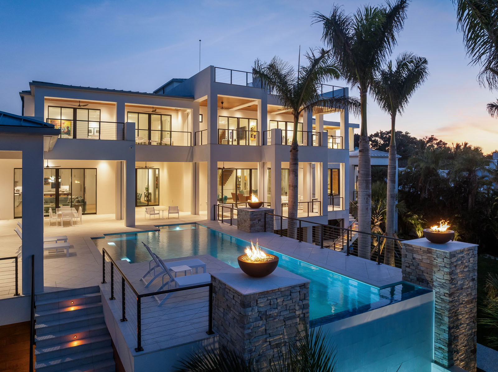 default Aerial dusk view of waterfront residence with pool, terraces, and coastal setting